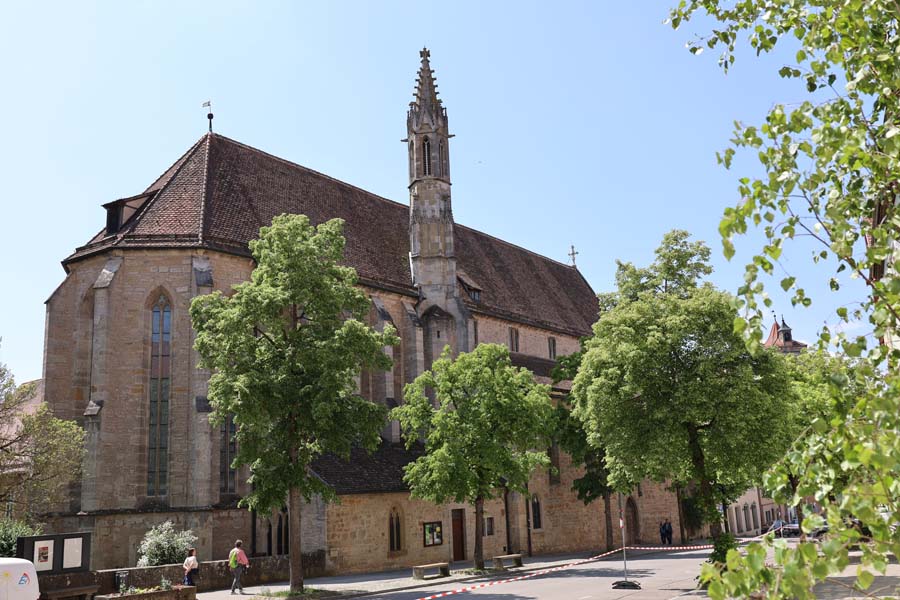 Blick auf die Kirche mit Laubbäumen, kleinen Turm unter blauen Himmel