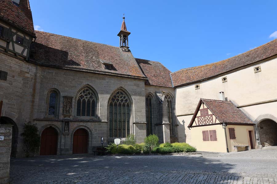 Außenansicht der Kirche mit Blick auf den Eingang und grünen Büschen vor der Kirche