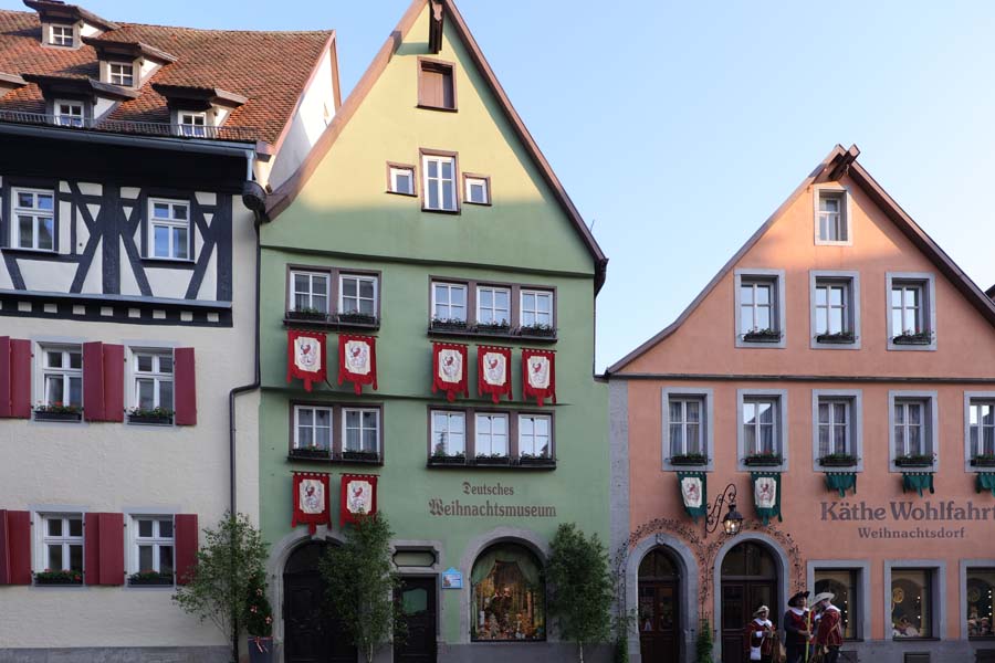 Außenaufnahme des grünen Hauses mit der Aufschrift Deutsches Weihnachtsmuseum, rechts neben orangenes Haus mit Aufschrift Käthe Wohlfahrt Weihnachtsdorf